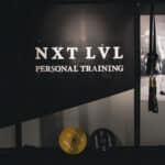 NXT LVL Amsterdam South studio interior with logo wall and weight plates